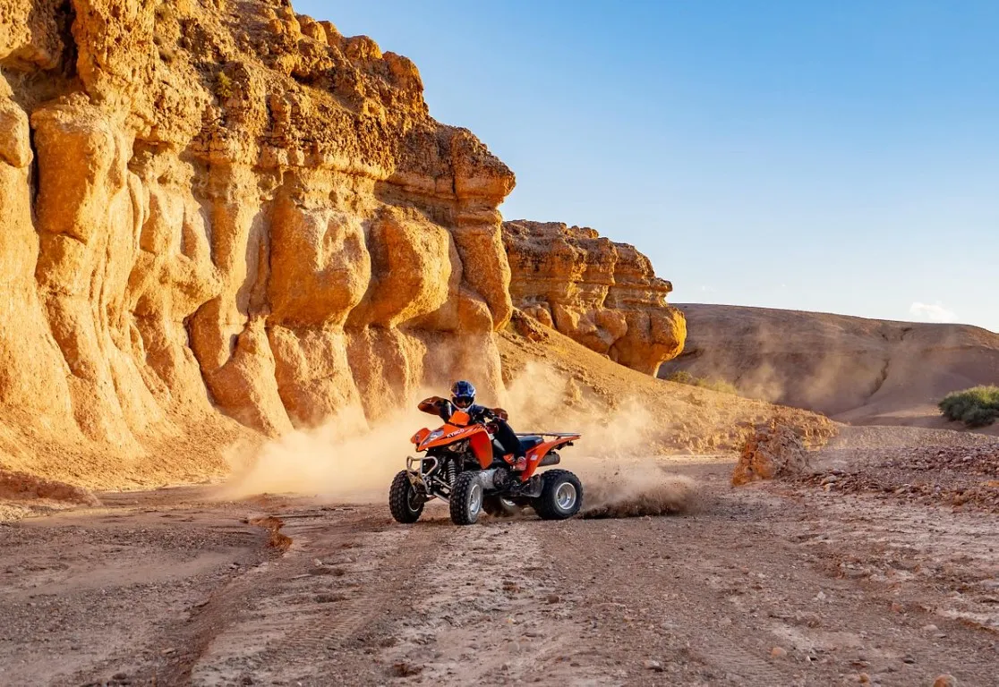 Quad biking through a rocky desert canyon near Marrakech