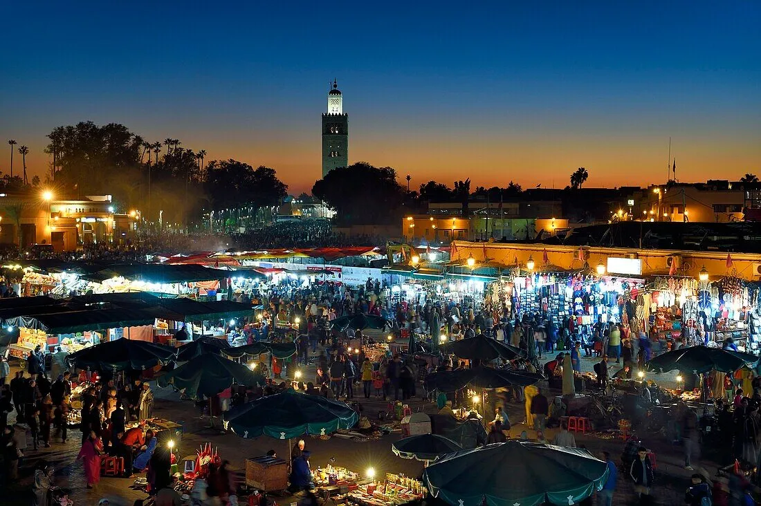 Jemaa el-Fna square in Marrakech at dusk with the Koutoubia minaret