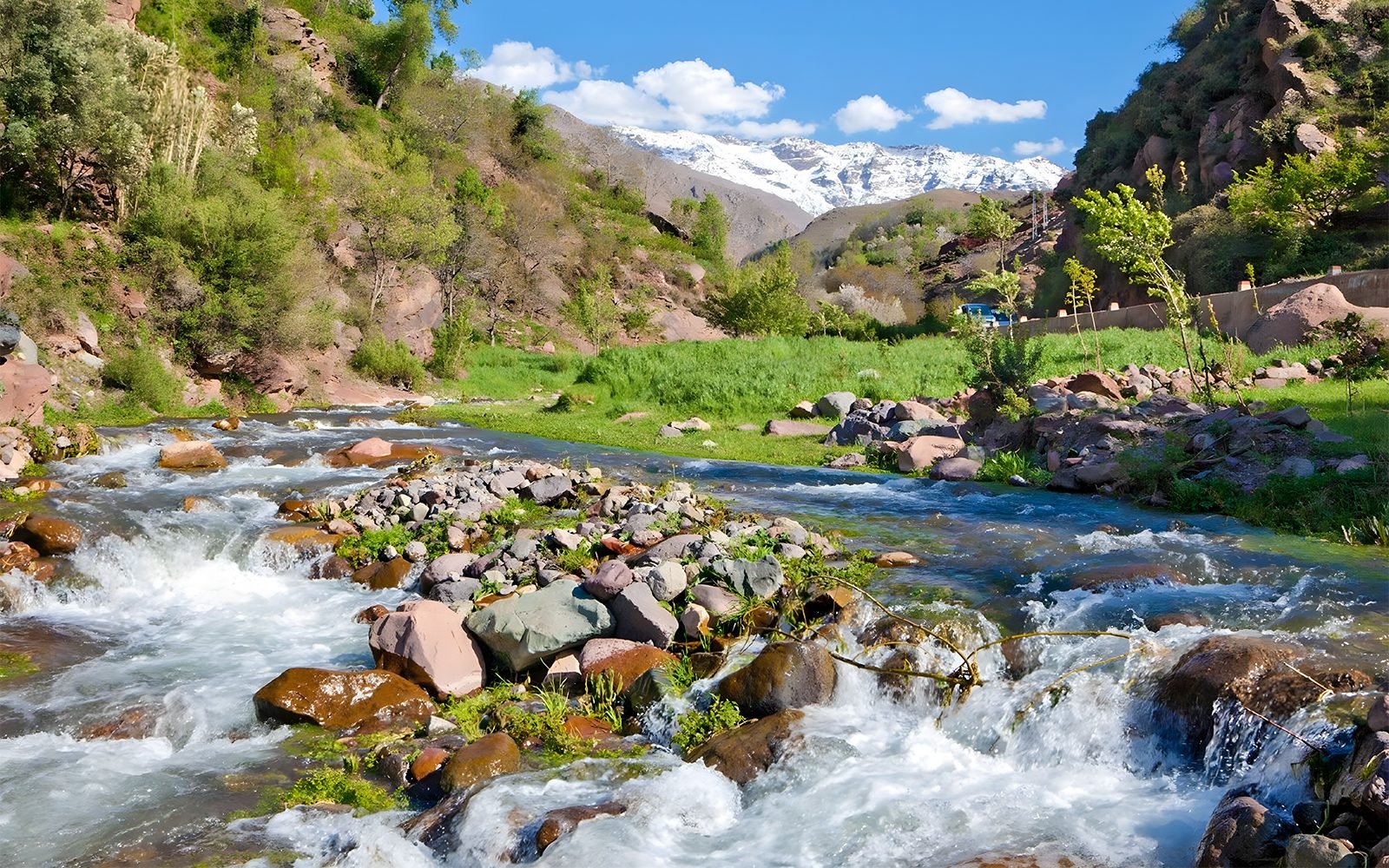 Torrent de montagne dans le Haut Atlas avec sommets enneigés au loin
